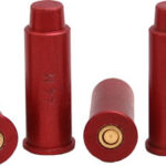 Five red shotgun shells on a white background, some upright and some lying on their sides with brass primers visible.