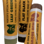 Three vintage makeup tubes with orange labels and brown caps arranged in a fan.