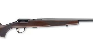 Side view of a long-barrel shotgun with a wooden stock and forend photographed in profile