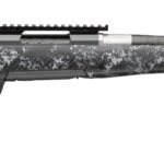 Bolt-action rifle with grey snow camouflage pattern, long barrel and muzzle brake laid horizontally