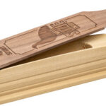 Wooden stamp with a carved handle resting on a wooden base, used to imprint designs.