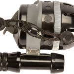 Close-up of a black fishing reel with a silver frame and a detachable handle against a white background.