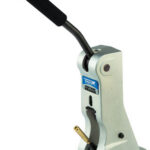 Manual lever-action punch tool with a long black grip and light metal body, used for making holes or indentations.