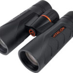Black compact binoculars with textured grip and orange accents, brand Athlon visible near the hinge.