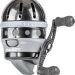 Close-up of a black and gray Muzzy bowfishing reel with a textured grip and two small handle knobs on the side, mounted on a short arm.