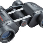 Black Tasco binoculars with a central focusing wheel and large objective lenses toward the viewer.