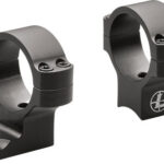 Pair of black metal scope rings with mounting bases, shown from an angled view to illustrate how they clamp around a rifle scope barrel.