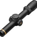 A riflescope with elevation and windage adjustment knobs mounted on a tube, viewed from an angle.