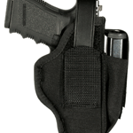 Black handgun secured in a black holster with a retention strap over the grip