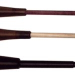 Three woodwind mouthpieces of different lengths and colors laid in a row