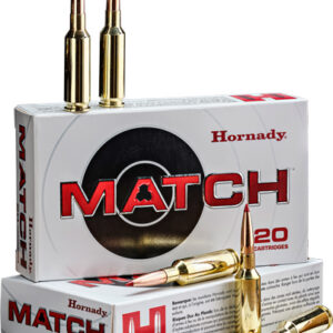 Two rifle cartridges standing upright on top of a Hornady MATCH ammunition box; other boxes and loose bullets nearby
