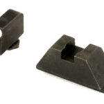 Two black plastic parts: a small rectangular piece with a metal screw and a larger wedge-shaped block with a central U-shaped groove.