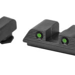 Front sight with orange fiber-optic insert and rear sight with two green fiber-optic dots on a white background; close-up of handgun sights.