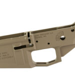 Tan AR-style rifle lower receiver component with trigger guard and magazine well, showing serial/maker markings.