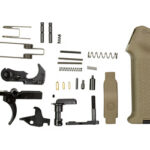 Disassembled pistol parts laid out beside a tan ergonomic grip module, showing springs, pins, and small components.",