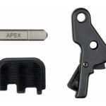 Set of small tool components: a metal key labeled APEX, a black plastic cap, and a black lever with two holes.