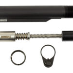 Disassembled firearm suppressor parts laid out: outer black housing, spring core, end cap, and two retaining rings.