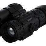 Black tactical riflescope with adjustable turrets and a secondary sight mounted on top, viewed from a slight angle.