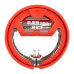 Red circular firearm optic with a clear central aperture and caliber markings 5.56 mm / .223