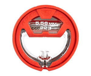 Red circular firearm optic with a clear central aperture and caliber markings 5.56 mm / .223