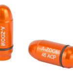 Two orange A-ZOOM .45 ACP practice dummy cartridges, one standing and one lying on its side.