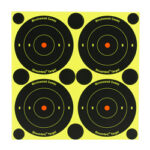Sheet of four black bullseye targets with orange centers on a bright yellow background.