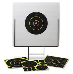 Target practice stand with a large black bullseye target on a sheet, and four paper targets laid on the ground nearby.