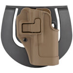 Tan polymer pistol holster attached to a gray backing plate, viewed from above.