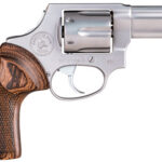 Profile view of a silver revolver with a wooden grip and exposed hammer, set against a white background.