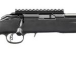 Side view of a black bolt-action rifle with adjustable stock and scope rail on top shelf railing the barrel's length impact.