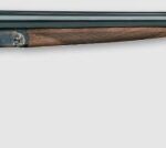 Double-barrel shotgun with a wooden stock and long metal barrels on a light background.