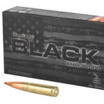 Box of Hornady Black ammunition with two rifle cartridges, one upright and one lying next to the box.