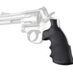 Side view of a silver revolver with a black textured grip on a white background