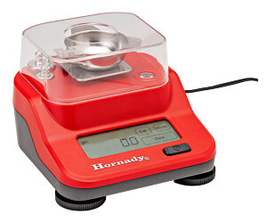Red compact electronic jewelry scale with a clear plastic cover and metal weighing pan on top.