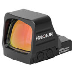 Holosun HS507COMP red dot sight with orange-lensed window, black polymer housing, shown from a front-left angle.