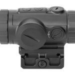 Close-up of a black reflex red-dot sight with adjustment dials, mounted on a rail/rail mount.