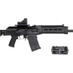 Black assault rifle with collapsible stock, long barrel and top rail, equipped with a detachable curved magazine and a spare magazine shown beside it.