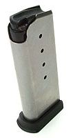 Silver handgun magazine with a black baseplate, standing upright on a small surface.