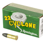 Box of Remington .22 Cyclone ammunition with two live rounds standing and lying beside it.