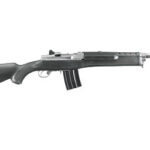 Profile view of a black assault rifle with a curved magazine and a long barrel, shown in side view.