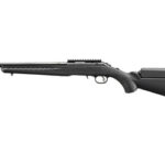 Black pump-action shotgun shown in profile with a long barrel and adjustable stock.
