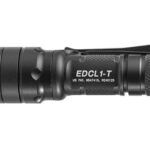Black EDCL-1-T tactical flashlight with knurled grip, warning label, and side switch.