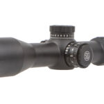 Black riflescope with adjustable turrets and long tube, used for precision aiming on a rifle.