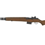 Bolt-action rifle with wooden stock and scope, photographed in profile against a white background, facing left.