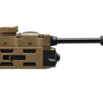 Tan modular firearm accessory with a rectangular body and a long cylindrical magnifier extending to the right, mounted on a rail