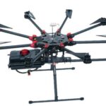 Octocopter agricultural drone with spray booms and chemical tank for field crop spraying