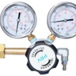 Propane gas regulator with two gauges and copper inlet/outlet, used to control gas pressure.