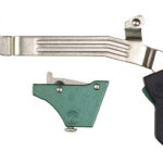 Disassembled bicycle brake lever and control hardware with green mounting pieces.