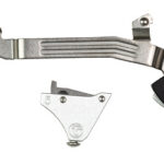 Two metal mechanical parts: a long curved silver lever with ridges and a black bracket with a white curved insert.