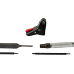 Set of electronics repair tools: black alligator clip with red tip, soldering iron handle with knurled grip, and four interchangeable tips laid out separately.